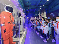 QINGZHOU, CHINA - MAY 23, 2023 - Primary school students watch and take photos of a space suit model at the Artificial Intelligence Learning...