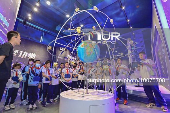 QINGZHOU, CHINA - MAY 23, 2023 - Primary school students listen to a staff member explain Beidou navigation knowledge at the Artificial Inte...