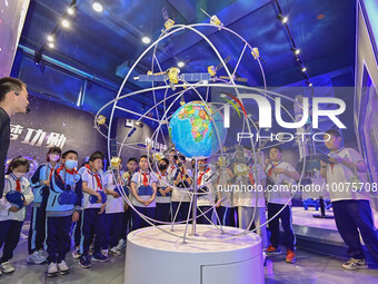 QINGZHOU, CHINA - MAY 23, 2023 - Primary school students listen to a staff member explain Beidou navigation knowledge at the Artificial Inte...