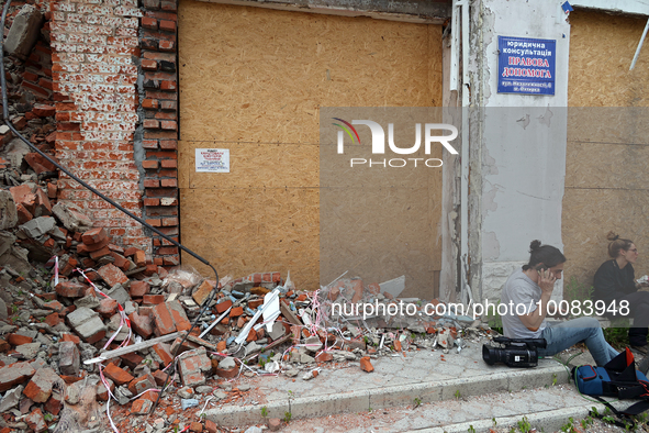 OKHTYRKA, UKRAINE - MAY 24, 2023 - Journalists sit near a pile of rubble at a building in the city centre damaged by Russian shelling, Okhty...