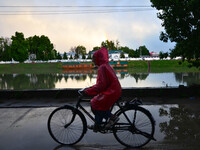 A man rides his bicycle on a rainy day in Srinagar, Indian Administered Kashmir on 25 May 2023. Rainfall will continue in the parts of Kashm...