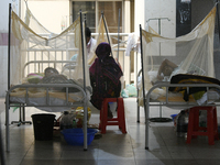 Bangladeshi dengue patients covered with mosquito nets suffer from dengue fever as they receive treatment at a Hospital in Dhaka, Bangladesh...