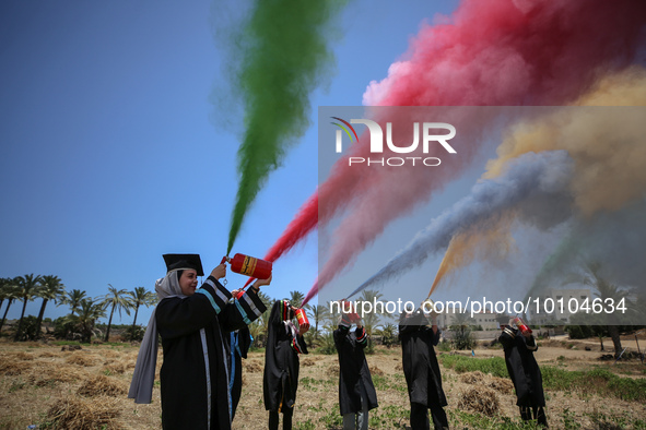 Students from the University of Palestine spray colors as they celebrate the end of the academic year in Gaza City on May 31, 2023. 