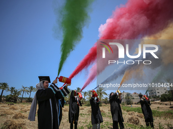 Students from the University of Palestine spray colors as they celebrate the end of the academic year in Gaza City on May 31, 2023. (