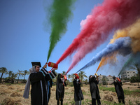 Students from the University of Palestine spray colors as they celebrate the end of the academic year in Gaza City on May 31, 2023. (