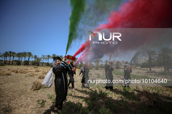 Students from the University of Palestine spray colors as they celebrate the end of the academic year in Gaza City on May 31, 2023. 