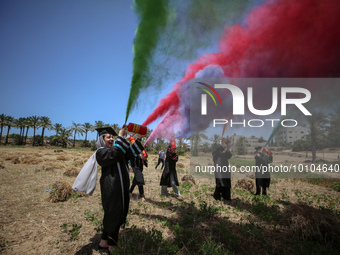 Students from the University of Palestine spray colors as they celebrate the end of the academic year in Gaza City on May 31, 2023. (