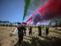 Students from the University of Palestine spray colors as they celebrate the end of the academic year in Gaza City on May 31, 2023. (