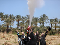 Students from the University of Palestine spray colors as they celebrate the end of the academic year in Gaza City on May 31, 2023. (