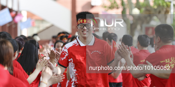 Teachers high-fives senior three students to cheer for the upcoming college entrance exam in Huai 'an, Jiangsu province, China, May 31, 2023...