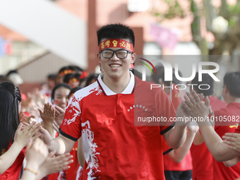 Teachers high-fives senior three students to cheer for the upcoming college entrance exam in Huai 'an, Jiangsu province, China, May 31, 2023...