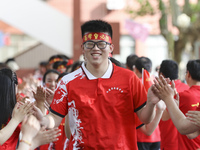 Teachers high-fives senior three students to cheer for the upcoming college entrance exam in Huai 'an, Jiangsu province, China, May 31, 2023...