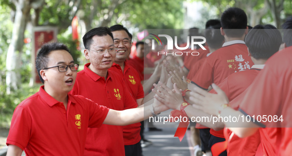 Teachers high-fives senior three students to cheer for the upcoming college entrance exam in Huai 'an, Jiangsu province, China, May 31, 2023...