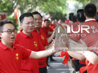 Teachers high-fives senior three students to cheer for the upcoming college entrance exam in Huai 'an, Jiangsu province, China, May 31, 2023...