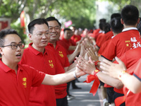 Teachers high-fives senior three students to cheer for the upcoming college entrance exam in Huai 'an, Jiangsu province, China, May 31, 2023...