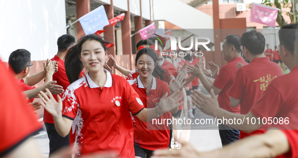 Teachers high-fives senior three students to cheer for the upcoming college entrance exam in Huai 'an, Jiangsu province, China, May 31, 2023...