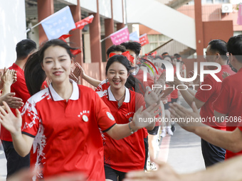 Teachers high-fives senior three students to cheer for the upcoming college entrance exam in Huai 'an, Jiangsu province, China, May 31, 2023...