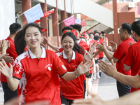 Teachers high-fives senior three students to cheer for the upcoming college entrance exam in Huai 'an, Jiangsu province, China, May 31, 2023...