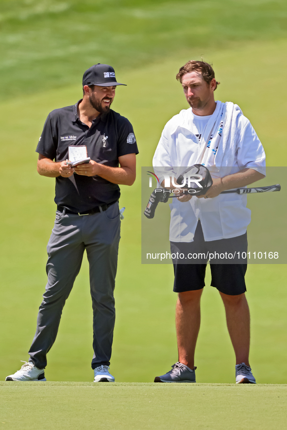 Mark Hubbard of Denver, Colorado talks with his caddie on the 18th green during the first round of the The Memorial Tournament presented by...