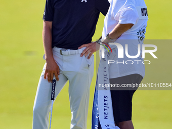 Tyrrell Hatton of High Wycombe, England talks with his caddie after putting on the 18th green during the first round of the The Memorial Tou...