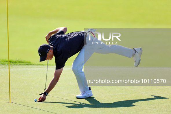 Tyrrell Hatton of High Wycombe, England picks up his ball after putting on the 18th green during the first round of the The Memorial Tournam...