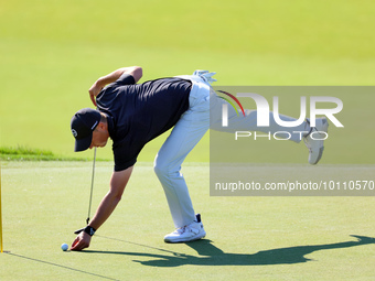 Tyrrell Hatton of High Wycombe, England picks up his ball after putting on the 18th green during the first round of the The Memorial Tournam...