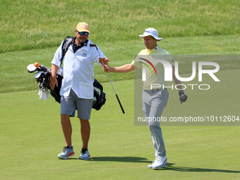 Peter Malnati of Knoxville, Tennessee passes his club to his caddie after hitting on the 17th green during the first round of the The Memori...