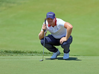 Matt Wallace of England lines up his putt on the 18th green during the first round of the The Memorial Tournament presented by Workday at Mu...