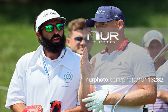 Matt Wallace of England talks with his caddie after hitting from the 16th tee during the first round of the The Memorial Tournament presente...