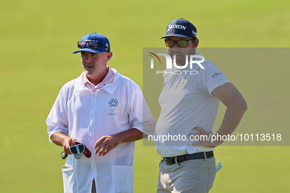 Matt NeSmith of Aiken, South Carolina waits with his caddie at the 18th green during the first round of the The Memorial Tournament presente...