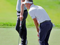 Luke Donald of England lines up his putt next to Thomas Detry of Brussels, Belgium on the 18th green during the first round of the The Memor...