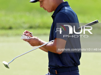 Justin Suh of San Jose, California marks his card as he walks off the 18th green after completing the  second round during  The Memorial Tou...