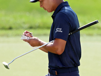 Justin Suh of San Jose, California marks his card as he walks off the 18th green after completing the  second round during  The Memorial Tou...