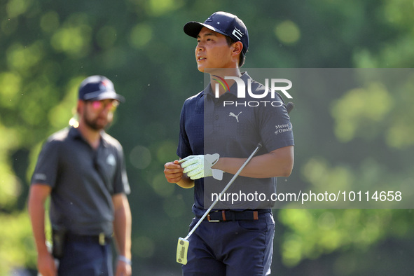 Justin Suh of San Jose, California removes his glove as he walks to the 18th green after hitting from the fairway the  second round during...