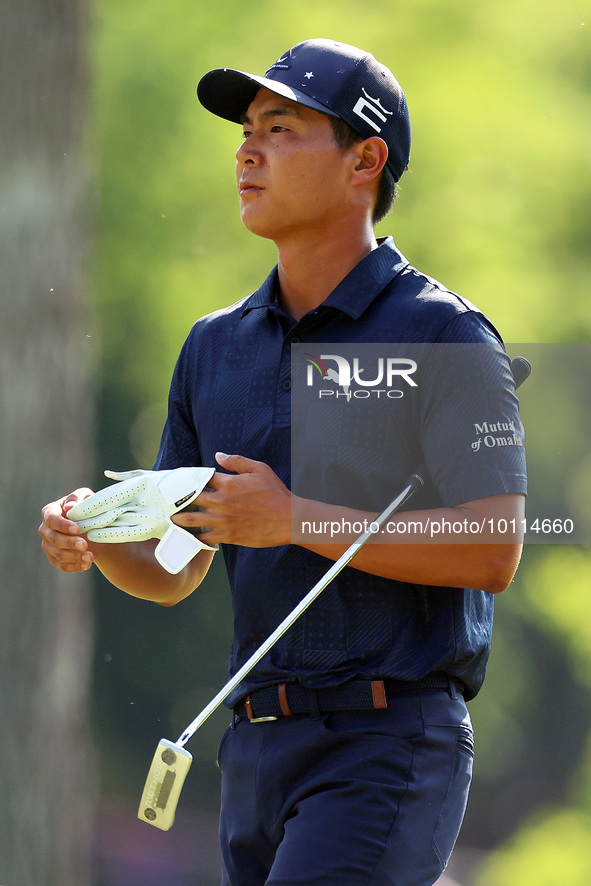 Justin Suh of San Jose, California removes his glove as he walks to the 18th green after hitting from the fairway the  second round during...