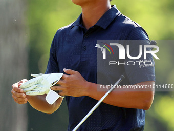 Justin Suh of San Jose, California removes his glove as he walks to the 18th green after hitting from the fairway the  second round during...