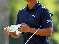 Justin Suh of San Jose, California removes his glove as he walks to the 18th green after hitting from the fairway the  second round during...