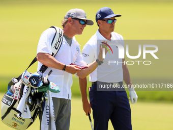 Rickie Fowler of Murrieta California looks down the 5th fairway with his caddie during The Memorial Tournament presented by Workday at Muirf...