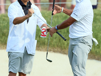 Hideki Matsuyama of Sendai, Japan exchanges clubs with his caddie on the 18th green during The Memorial Tournament presented by Workday at M...