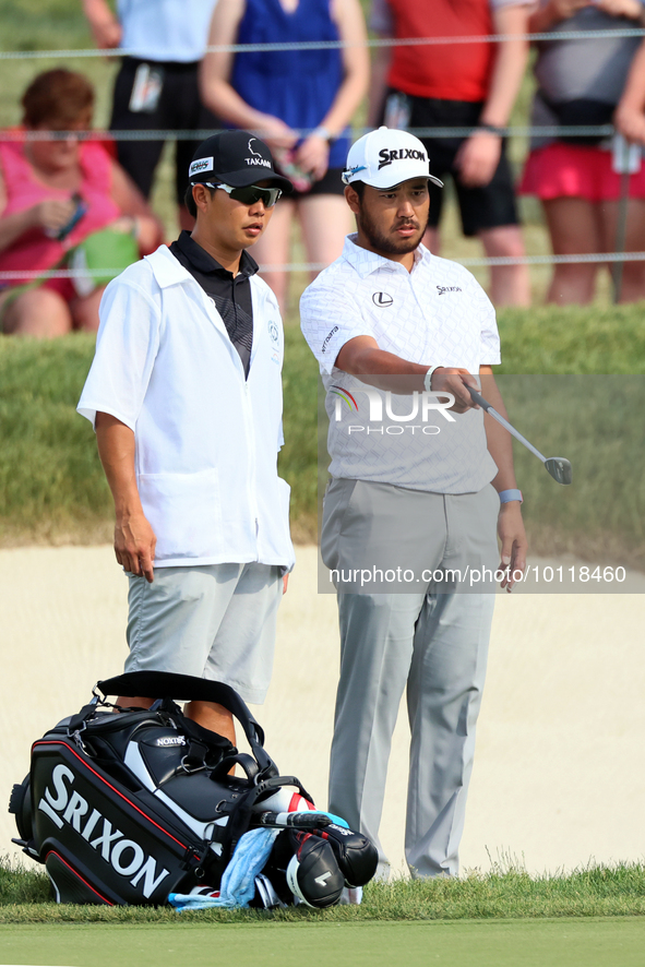 Hideki Matsuyama of Sendai, Japan looks over the 18th green with his caddie during The Memorial Tournament presented by Workday at Muirfield...