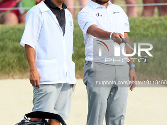 Hideki Matsuyama of Sendai, Japan looks over the 18th green with his caddie during The Memorial Tournament presented by Workday at Muirfield...