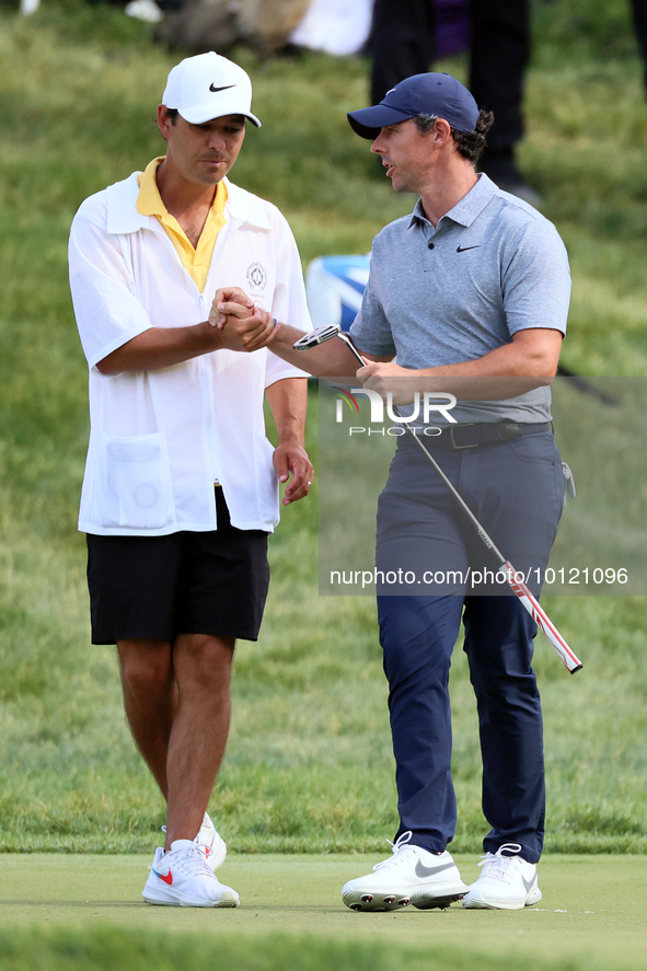 Rory McIlroy of Holywood, Northern Ireland shakes hands with his caddie on the 18th green during The Memorial Tournament presented by Workda...