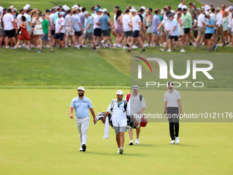 Jon Rahm of Barrika, Spain and Patrick Rodgers of Jupiter, Florida walk on the 18th fairway during The Memorial Tournament presented by Work...