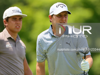 Emiliano Grillo of Argentina follows his shot from the 18th tee while Garrick Higgo of Stellenbosch, South Africa looks on during The Memori...