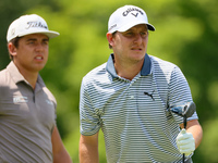 Emiliano Grillo of Argentina follows his shot from the 18th tee while Garrick Higgo of Stellenbosch, South Africa looks on during The Memori...