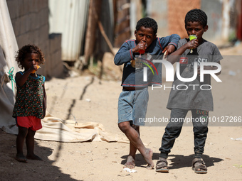 Palestinian children eat ice drinks outside their home in a poor neighborhood in Beit Lahia in the northern Gaza Strip, on June 5, 2023.  (