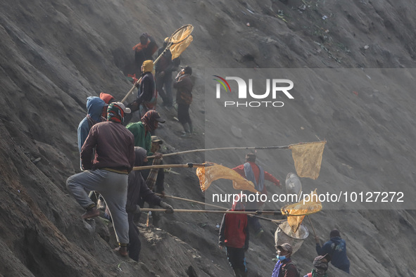 PROBOLINGGO, INDONESIA - JUNE 5: Tenggerese walk and hike carrying agricultural products and livestock to be sacrificed during the Yadnya Ka...