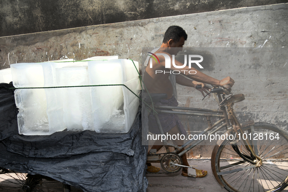 A worker carries ice bars on a van to deliver nearest juice shop during  a heat wave in Dhaka, Bangladesh, May 06, 2023. The prevailing mild...