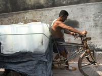 A worker carries ice bars on a van to deliver nearest juice shop during  a heat wave in Dhaka, Bangladesh, May 06, 2023. The prevailing mild...