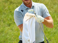 Danny Willett of Sheffield, England cleans off his club after hitting from the bunker on the 17th green during The Memorial Tournament prese...